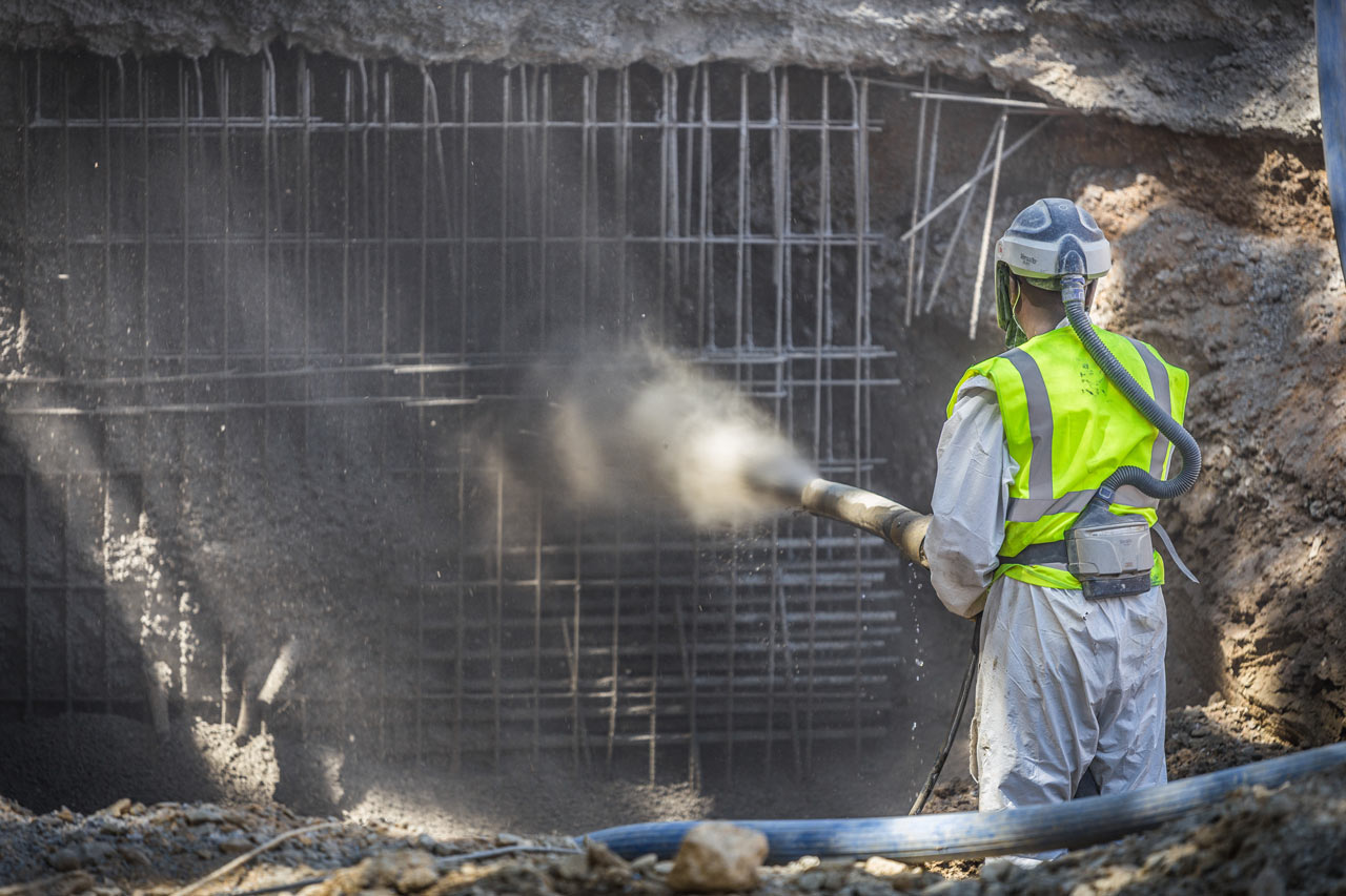 A worker spraying shotcrete on a wall