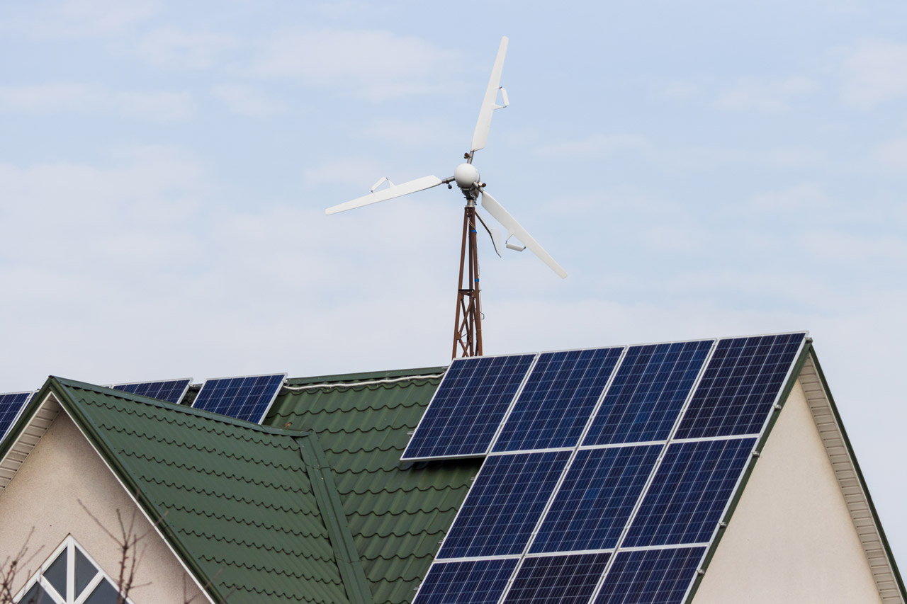 A house with solar panels and a windmill on the roof
