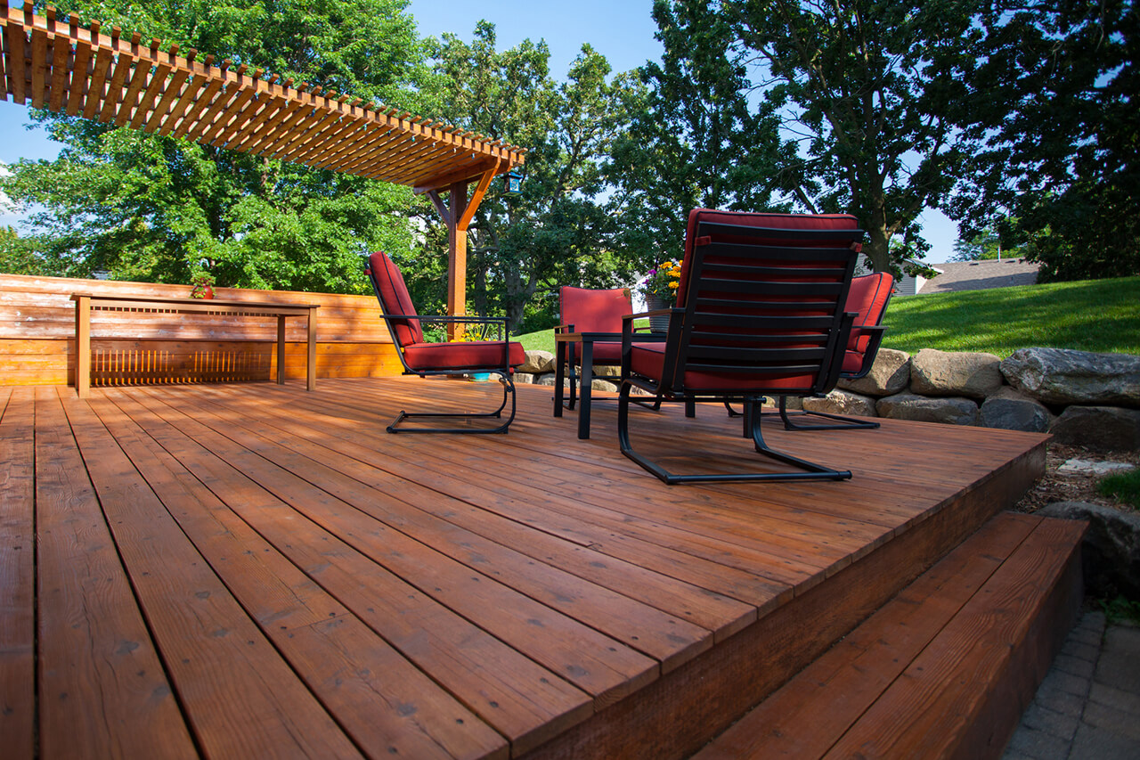wooden deck in backyard with pergola and patio furniture