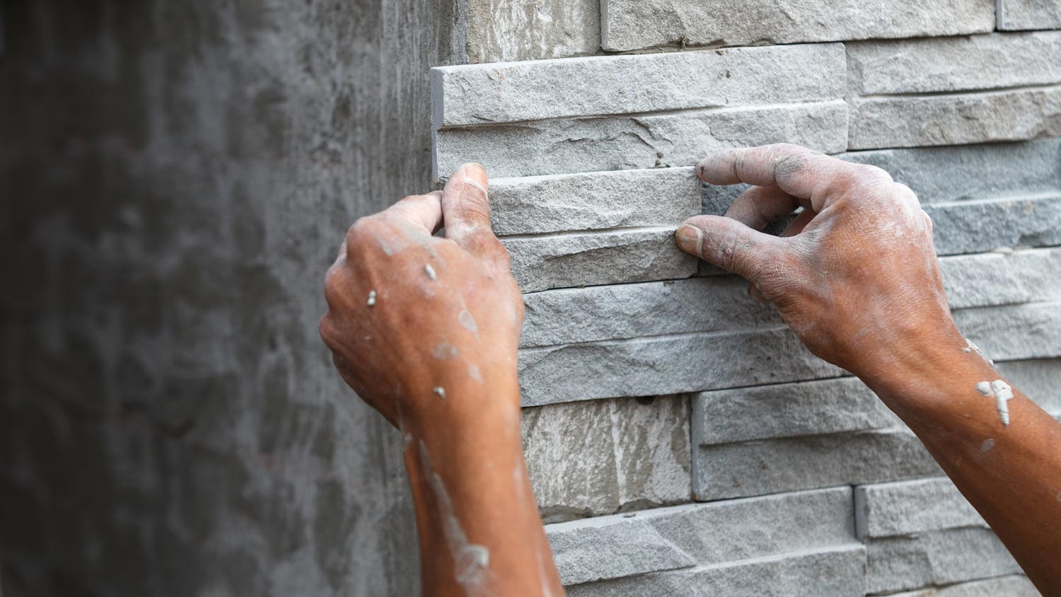 A worker building a stone wall