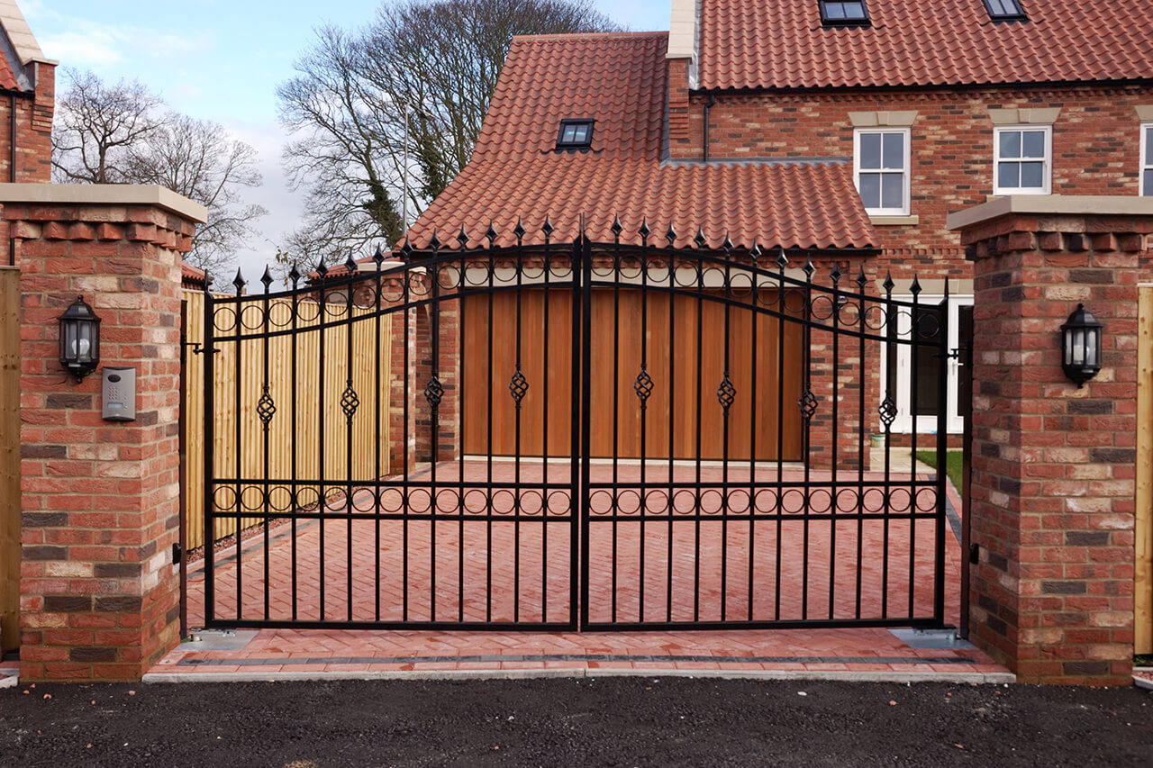 iron security gate at the end of driveway of home
